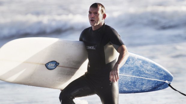 Tony Abbott, pictured surfing in 2014, went to hospital for a "couple of stitches" after encountering rough surf conditions on Friday morning.
