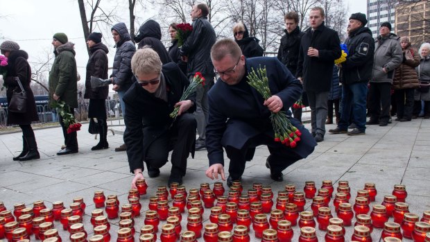Men place candles as they arrive at a farewell ceremony to slain opposition leader Boris Nemtsov in Moscow on Monday.