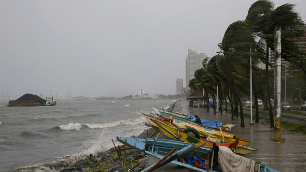 Small fishing boats are placed by the seawall as strong winds and rain brought by Typhoon Koppu hit Manila.