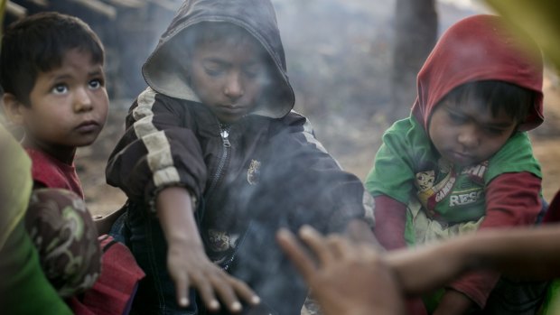 A family who fled violence in Salipara village in Myanmar sit at a Rohingya refugee camp in Bangladesh.