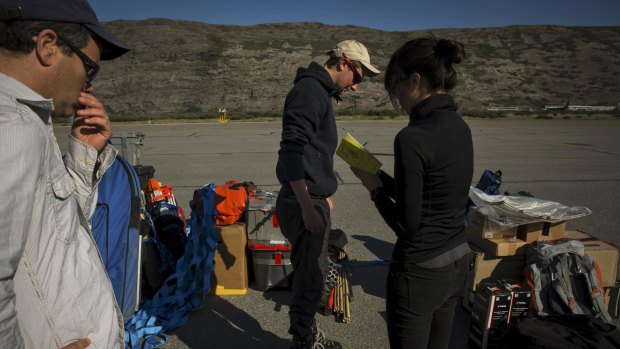 Laurence Smith, head of the geography department at the University of California, Los Angeles, left, and Vena Chu, right, add up the weight of baggage researchers plan to take out for fieldwork before leaving from Kangerlussuaq in July. 
