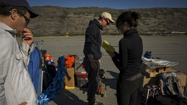 Laurence Smith, head of the geography department at the University of California, Los Angeles, left, and Vena Chu, right, add up the weight of baggage researchers plan to take out for fieldwork before leaving from Kangerlussuaq in July. 