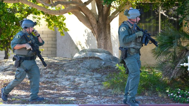 Riverside Country Sheriffs Deputies walk along a street in Palm Springs after two officers were shot dead. 