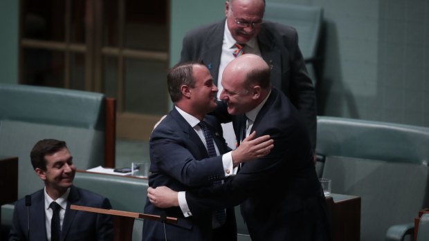 Liberal MP Tim Wilson is embraced by colleague Trent Zimmerman after his speech.