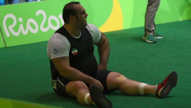 Behdad Salimi  of Iran sits down and protests during the weightlifting.