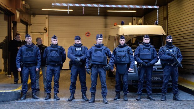 Police stand guard outside the offices of French daily newspaper Liberation as the remaining members of the Charlie Hebdo editorial staff arrive for a meeting.