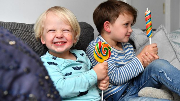 Brothers Sebastian, two, and Sam, three, enjoy a lollipop. 