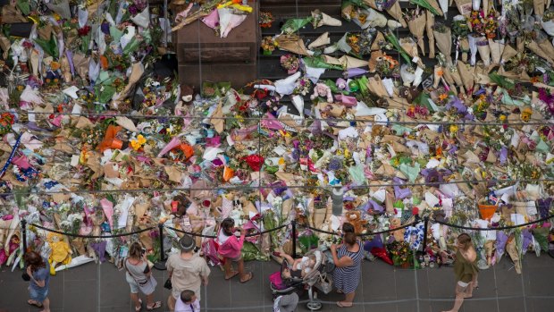 People lay flowers at the memorial to the victims in the wake of the Bourke Street attack.