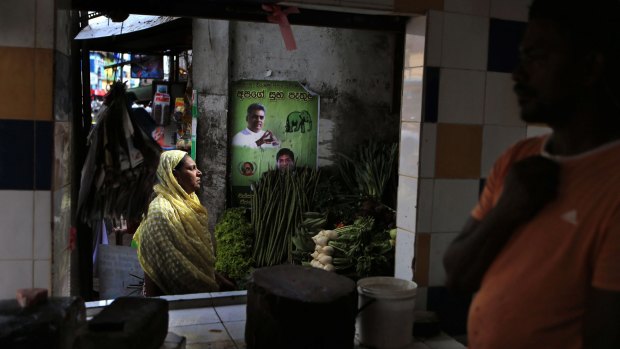 A Sri Lankan woman shops for vegetables on Tuesday near election posters for Prime Minister Ranil Wickremasinghe
