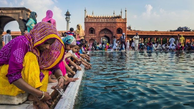 People wash themselves with water from an artificial pond at the premises of Jama Masjid, Delhi, as they prepare for Iftar - The evening meal to breakfast.