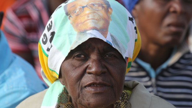 A supporter of Zimbabwean President Robert Mugabe waits for him to arrive at a rally on Friday.
