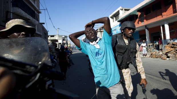 A man is detained by police in Port-au-Prince during an anti-government protest.