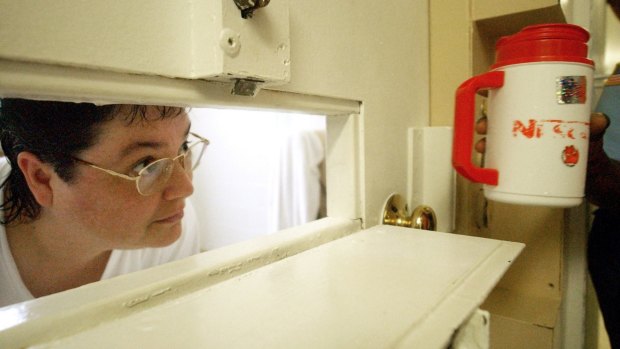 Kelly Renee Gissendaner looks through the slot in her cell door in Atlanta in 2004.