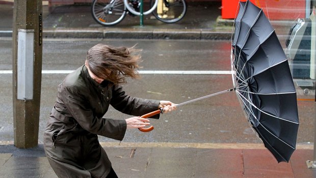 Commuters battle the conditions in the Sydney CBD.