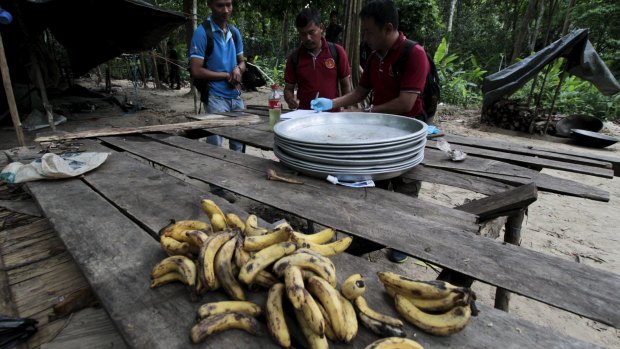 Security forces and rescue workers inspect an abandoned trafficking camp in Thailand's southern Songkhla province.