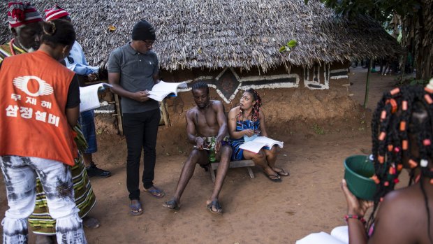 Cast and crew talk over the script together during filming in Illah, Nigeria.
