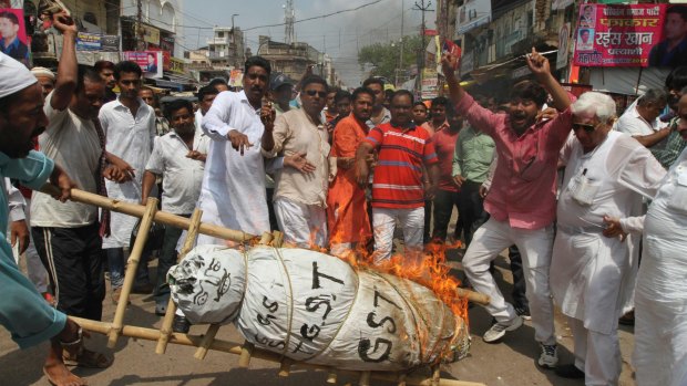 Indian traders burn an effigy of the Goods and Services Tax during a strike against its implementation in Allahabad, India, on Friday. 