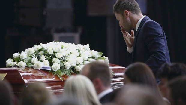 Michael Clarke pauses at his friend Phillip Hughes' casket as he makes his way to the lectern to deliver his tribute.