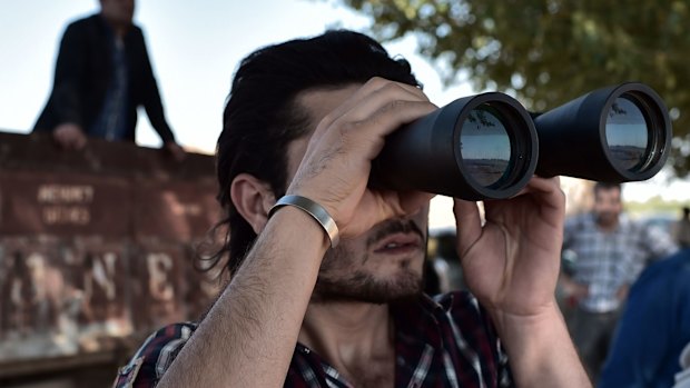 WATCHFUL: A Kurdish man monitors fighting in Kobane.