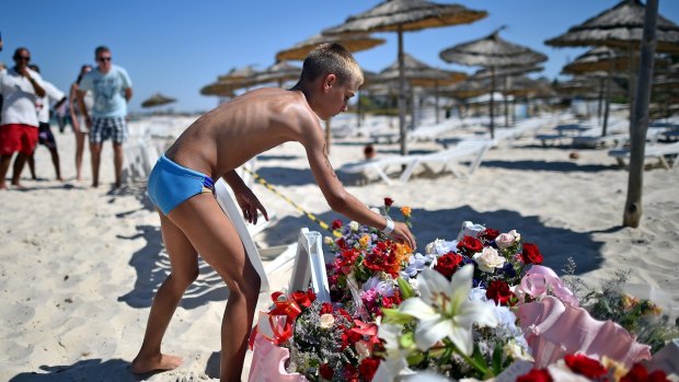 A boy leaves flowers at a memorial on the Tunisian beach where the attack took place.