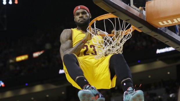 Star power: Cleveland Cavaliers forward LeBron James hangs onto the basket after a dunk.