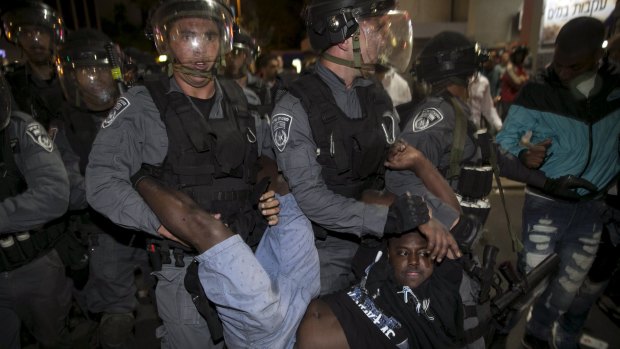 An Israeli, of Ethiopian origin, is carried by policemen at a protest in Tel Aviv on Sunday. 