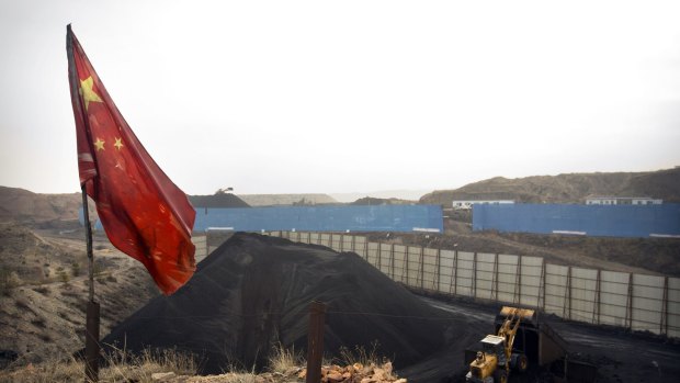 A Chinese flag flutters as a loader moves coal at a coal mine near Ordos in northern China's Inner Mongolia Autonomous Region last year. 