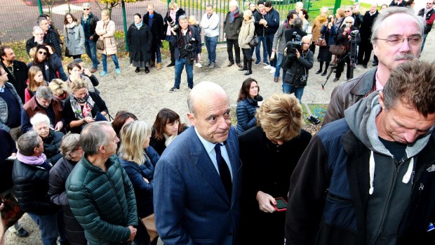 Former prime minister and Bordeaux's mayor Alain Juppe, centre, a candidate for France's upcoming presidential primary election, queues to vote on Sunday.