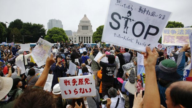 Protesters hold anti-war placards in front of the National Diet building during a rally in Tokyo last month.