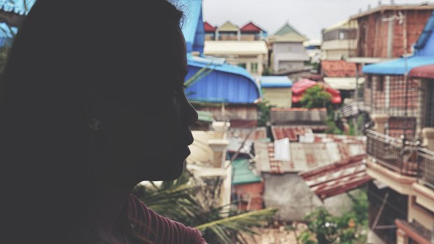 A woman looks out over the neighbourhood at a rescue home in Cambodia.