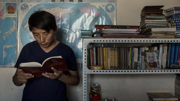 Tashi Wangchuk, a shopkeeper and education advocate, studies Tibetan at home in Yushu, China, earlier this year. 