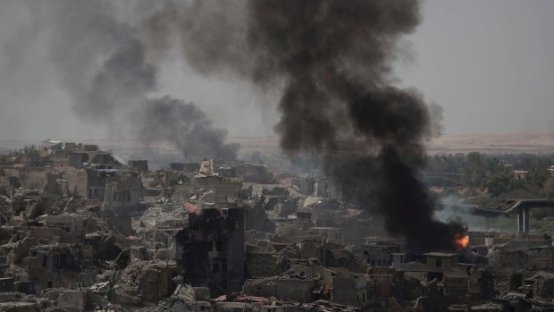 Smoke billows from Islamic State positions on the edge of the Old City, a day after Iraq's Prime Minister declared "total victory" in Mosul.