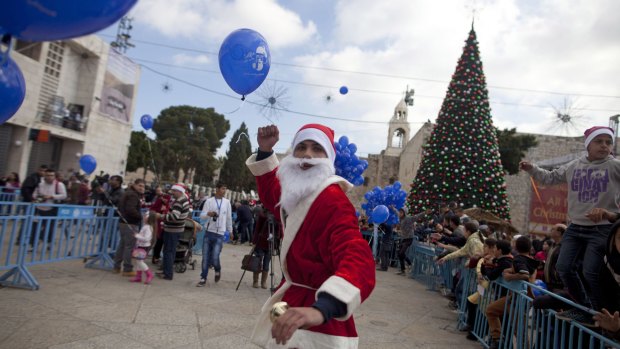 Santa dashes back to his sleigh outside the Church of the Nativity in Bethlehem, West Bank at the spot many pilgrims believe Jesus was born.