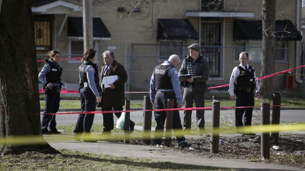 Police investigate the scene of a shooting at the intersection of 93rd Street and Harper Avenue in Chicago, on March 17.