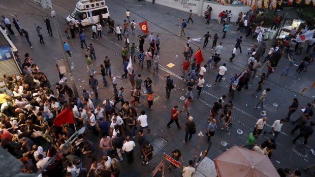 Demonstrators run from tear gas used by riot police in Istanbul during a protest in central Istanbul, which erupted after the Suruc blast. Protesters blamed the government for not preventing the bombing. 