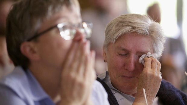 Democrat voters react while watching the election results.