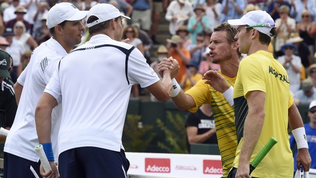 Mike Bryan and Bob Bryan of the United States shake hands with Lleyton Hewitt and John Peers after the doubles match.