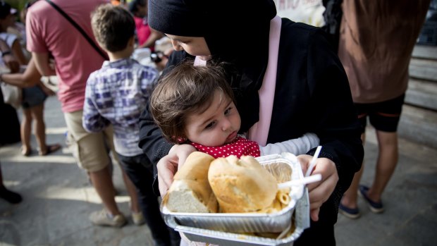 Refugees are fed in a park near the port of Mytilini in Lesbos, Greece, on Wednesday.