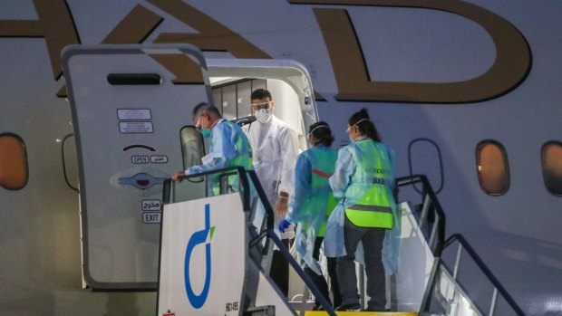 Bio security staff board a plane carrying tennis players and support teams upon its arrival in Melbourne last month. The international borders are closed, but not to everyone.