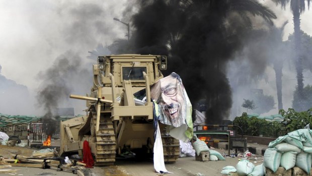 A torn poster of deposed Egyptian president Mohamed Mursi is seen as riot police clear his supporters from a sit-in outside Cairo's Rabaa al-Adawiya mosque in August 2013. Human Rights Watch has said nearly 1000 people were killed in the operation, the vast majority of them civilians.