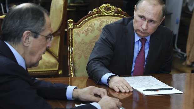 Russian President Vladimir Putin, right, listens to Russian Foreign Minister Sergey Lavrov during their meeting in the Kremlin in Moscow.