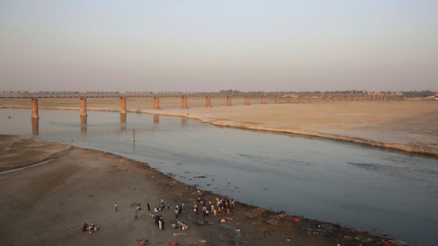 Indians stand on the banks of the River Ganges, in Allahabad, India.