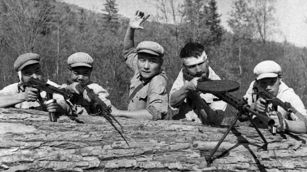 Wang Qiuhang, centre, and other members of a military construction squad in 1970, enacting a fictitious battle scene near the Soviet border.