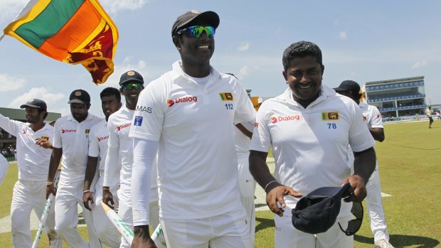 Sri Lankan cricketers Angelo Mathews (centre) and Rangana Herath acknowledge the crowd with their teammates.