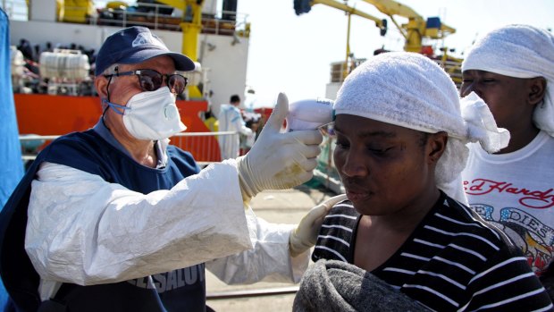 A woman has her temperature checked after she disembarked from the Aquarius  vessel in Messina.