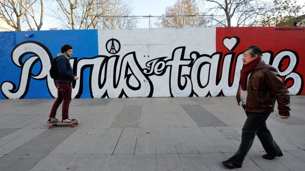 A boy skates by a painted wall reading "Paris, I love you", in Paris last week. 