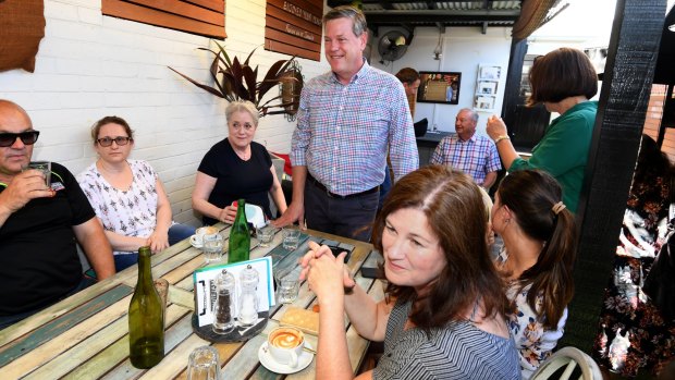 Queensland Opposition Leader Tim Nicholls head to a cafe.