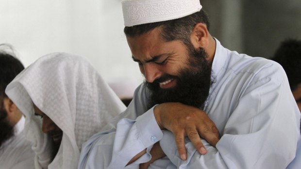A man cries as he offers funeral prayers for the late Taliban leader Mullah Omar.