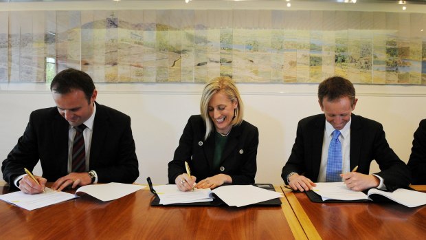 Chief Minister Katy Gallagher and (R) Shane Rattenbury and (L) Andrew Barr all smiles after putting pen to paper and signing an agreement to form a government at the ACT Legislative of Assembly, Canberra in November 2012.