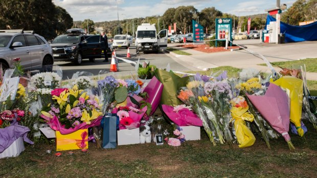 Flowers on Saturday at the scene of the fatal stabbing at the Queanbeyan Caltex service station. 